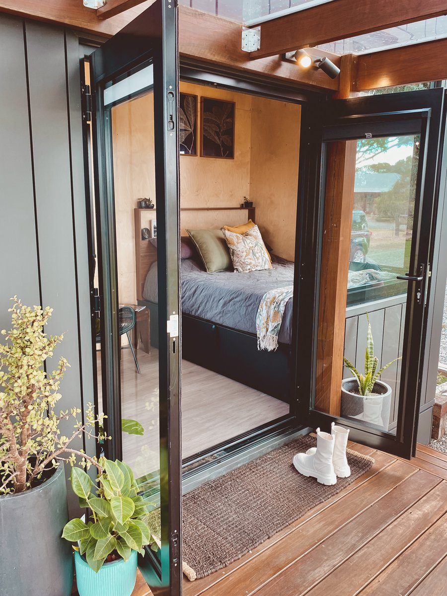 Both glass doors open onto the bedroom, boots on the mat