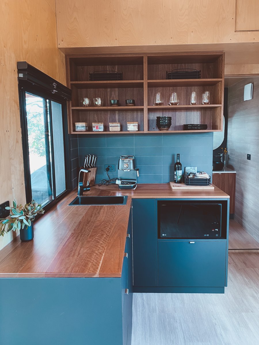 The kitchen with blue cabinetry and a timber benchtop