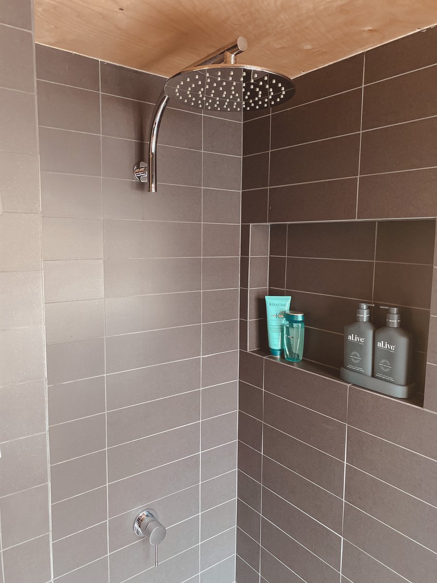 The tiled shower with a rainfall head and a window